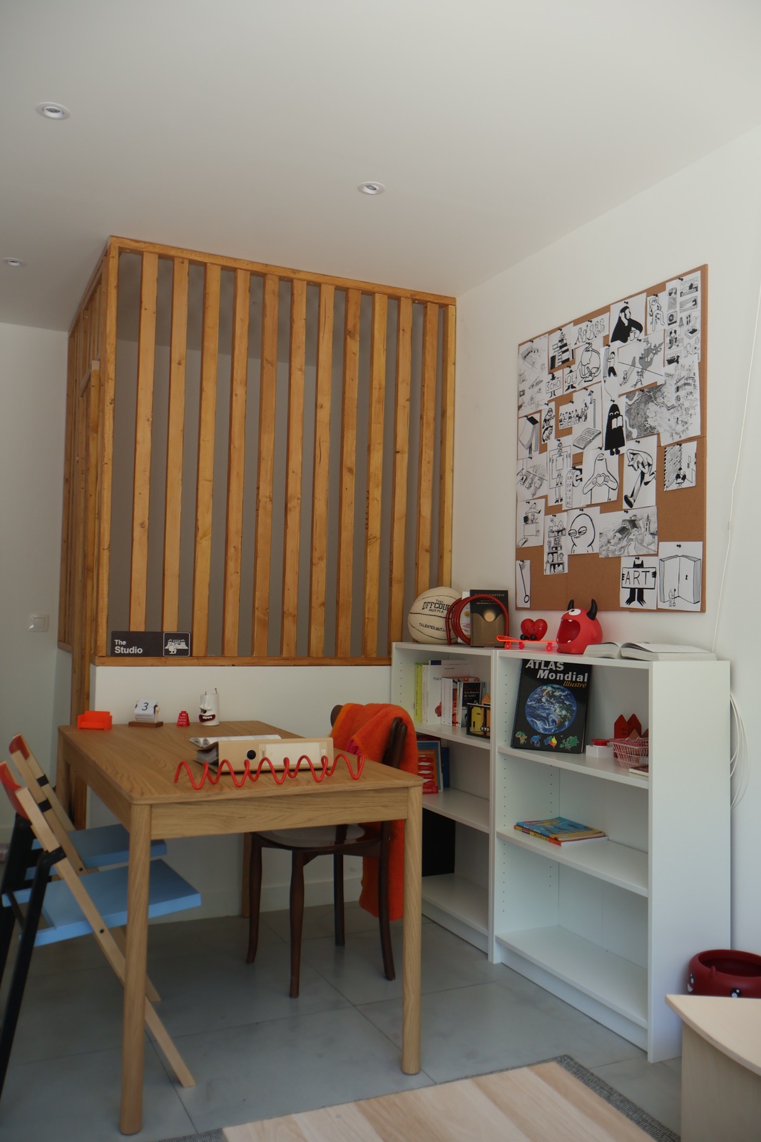 Coin de travail du centre La Passerelle : table, bibliothèque et claustra en bois