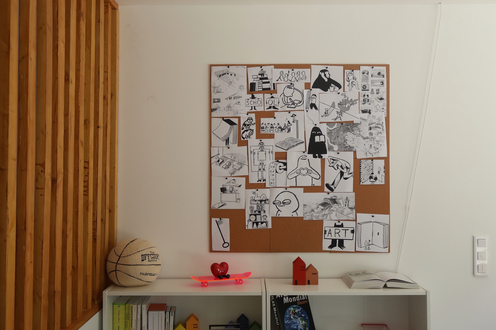 Panneau de dessins en noir et blanc au-dessus de la bibliothèque du centre La Passerelle