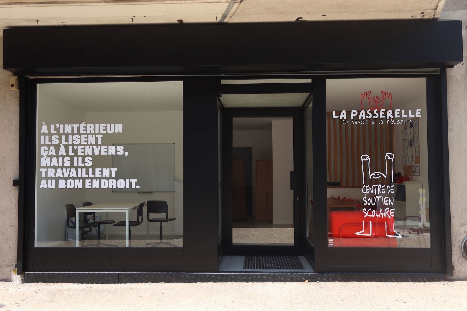 Devanture du centre de soutien scolaire La Passerelle, 15 avenue Jean Laugère à Arnouville : vitrines noires, logo et salle de cours visible depuis la rue